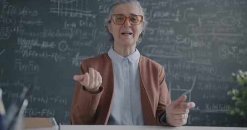 Woman Teacher Explaining Math Problems in Classroom
