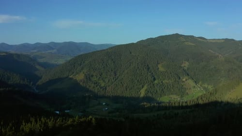 Aerial Mountain Valley Village View with Charming Green Rocky Peaks Blue Sky