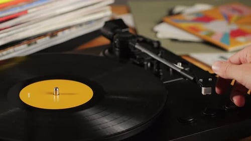 Hand Placing Record Player Arm on Vinyl Record