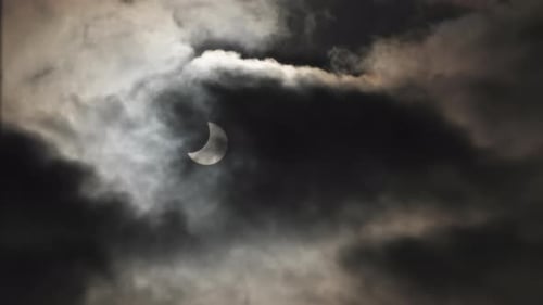 Éclipse solaire dans un ciel sombre et nuageux