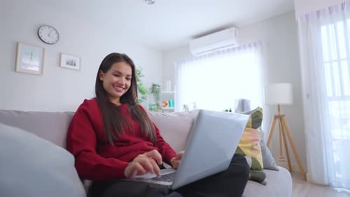 Woman Working on Laptop Comfortably at Home