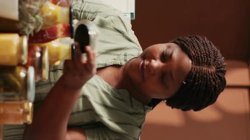 Woman Decanting Colorful Pasta into Brown Paper Bag