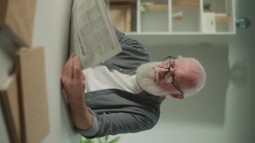Senior Adult Reading Newspaper Indoors