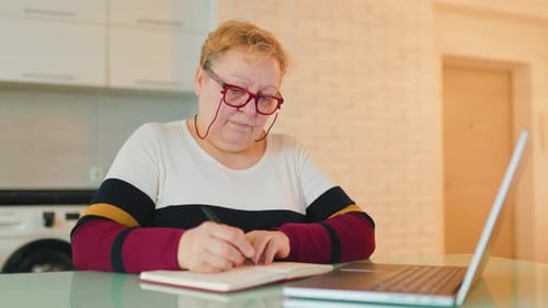 Senior Woman Working at Laptop in Home