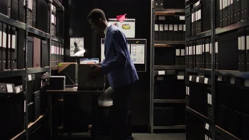 Professional Man Works with Files in Small Office