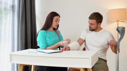 Caring Doctor Attending to Patient with Arm Cast