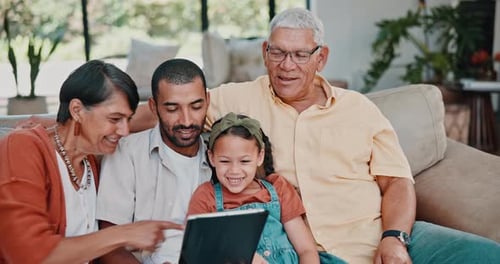 Family of Four Smiling and Laughing at Tablet