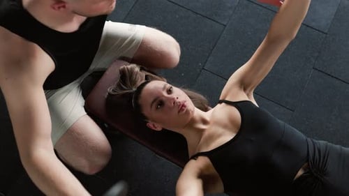 Weightlifting Assistance Male Personal Trainer Supports Woman at the Gym