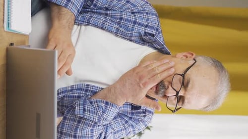 Man Rubs Jaw with Expression of Pain