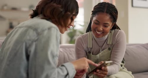 Femmes, amis et partage sur le canapé avec téléphone, détendez-vous ou lisez avec un mème