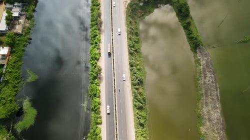 Vehicles are moving from a beautiful road in Dhaka city nearby a lake