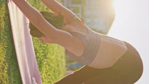 Woman Stretching Outdoors Doing Yoga On Grass