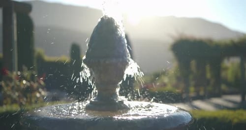 Nahaufnahme, schöner Springbrunnen im Garten im Freien, Sonne und Linsenblende Laube