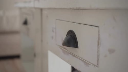 Putting a cable in a drawer and closing it.