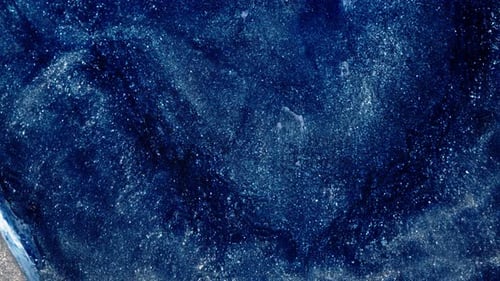 Shimmering blue substances mix in artistic abstract view of fluid textures