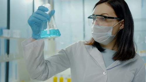 Scientist Holding Beaker with Blue Chemical Liquid
