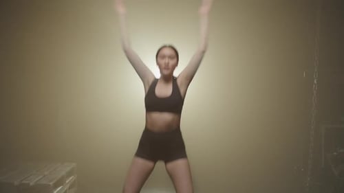 Active Motivated Sporty Fit Asian Female Doing Jumping Jacks Exercise in Gym