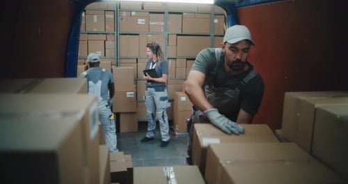 Multiethnic Workers Loading Cardboard Boxes in Delivery Truck From Logistics Retail Warehouse