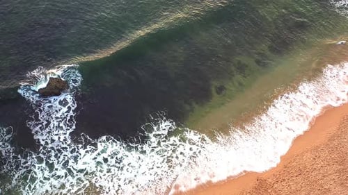 Aerial Drone Capturing Scenic Ocean Waves on Sandy Seashore
