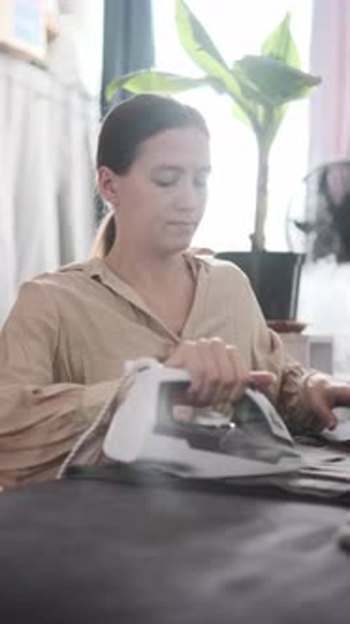 Femme repassant des vêtements dans un intérieur lumineux, routine quotidienne, tâches ménagères