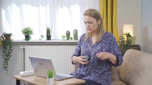 Woman Types on Laptop and Plugs It In