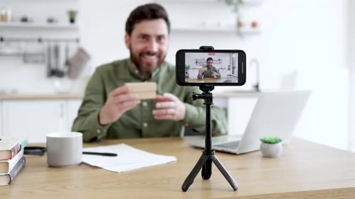 Man Records Product Review on Smartphone in Kitchen