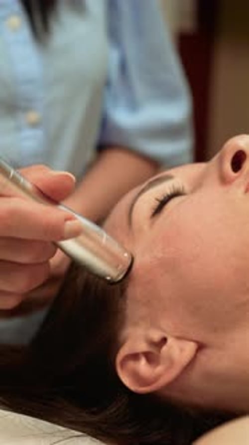 Skincare Professional Performing Darsonval Treatment on Temple Vertical Orientation Aesthetic Expert