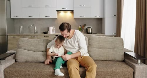 Father and Child Watching Tablet Together at Home