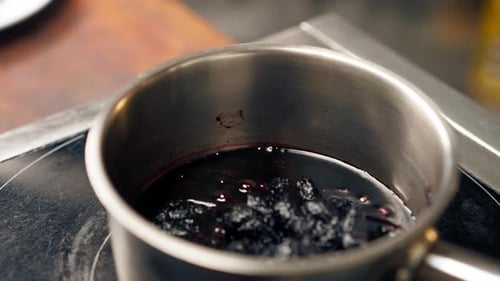 Simmering Berries Create Sweet Dessert Sauce on Stove