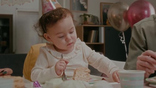 Baby Eating Cake with Family at Birthday Party