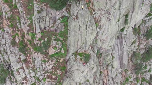 Climbers Ascending Steep Rock Face on Sunny Day