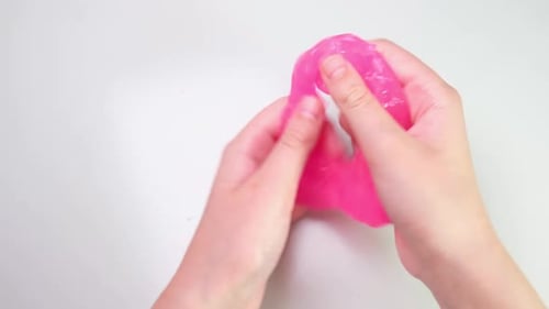 Playing with Textured Slime with Bubbles Stretching the Gooey Substance Female Teen Hand Holding