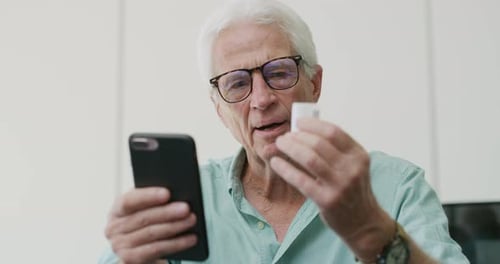 Senior Man Discusses Medication with Doctor on Video Call