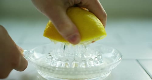 Squeezing Fresh Lemon in Glass Juicer