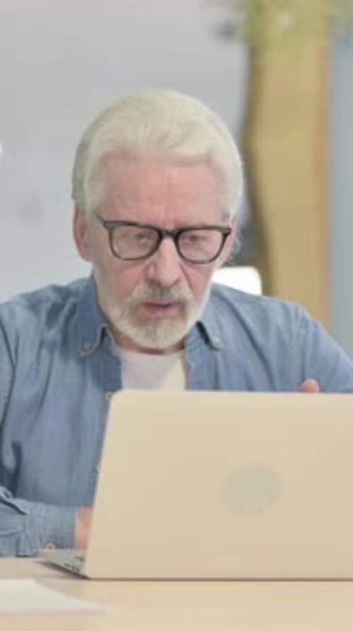 Online Video Chat by Old Man in Office, vertical video