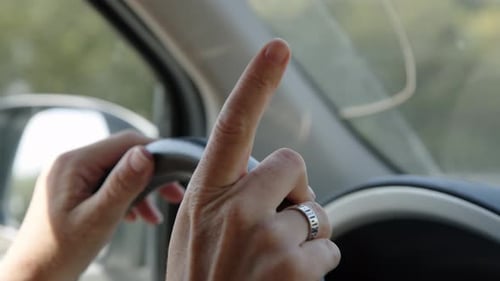 Close Up View of Young Female Hands Holding Steering Wheel in Car