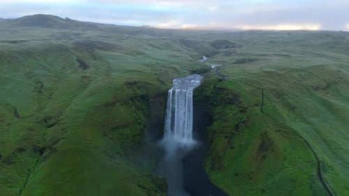 Sweeping Aerial View of Icelandic Waterfall Amid Lush Greenery and Flowing River