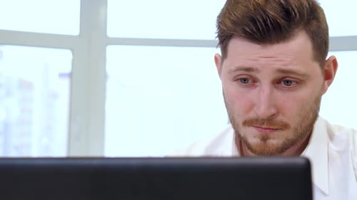 Focused Male Manager Engaged with Laptop in Modern Office