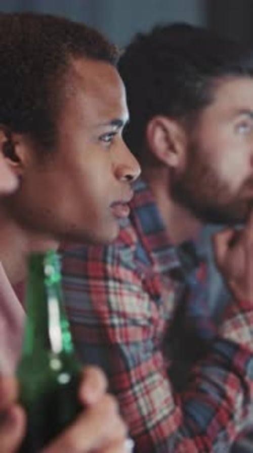 Concentrated men watching with concern, close up indoors