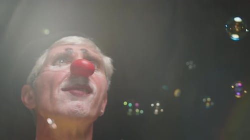 Clown with Red Nose Surrounded by Bubbles