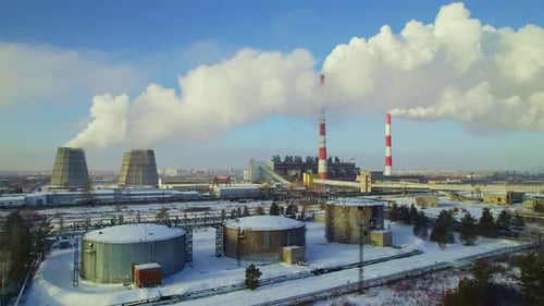 Industrial Plant With Smokestacks Emitting Smoke in Winter