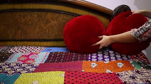 Red Pillows Arranged on Quilted Bedspread