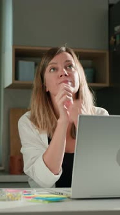 Woman Thinking and Looking Away from Laptop at Home