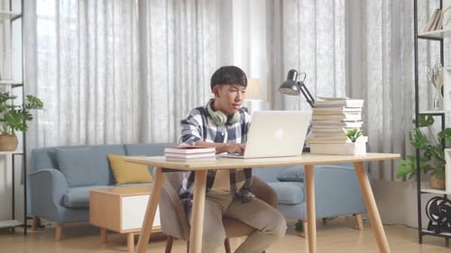 Young Adult Working on Laptop at Home Desk