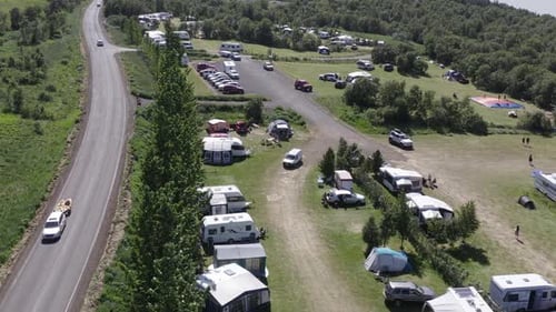 Camping site Hallormsstaður in east Iceland on sunny day, parked vehicles, aerial
