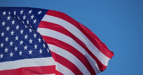 American Flag Waving Proudly Against Blue Sky