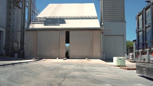 Cargo trailer truck parking in reverse in a grain warehouse warehouse to unload merchandise