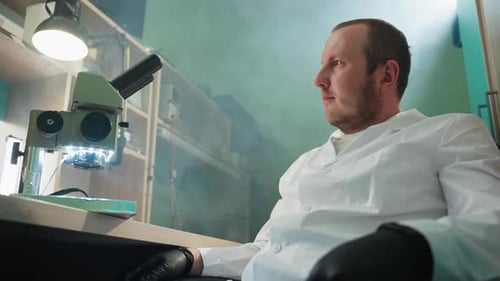 Scientist with Microscope in Modern Bright Lab