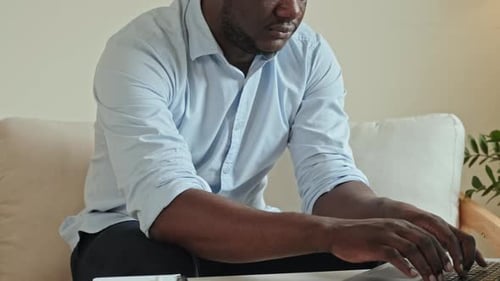 Man Calculating Finances and Writing in Notebook