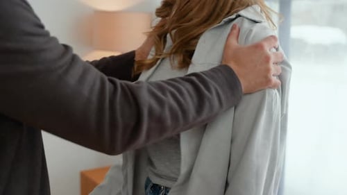 Man Adjusts Woman's Shirt at Home